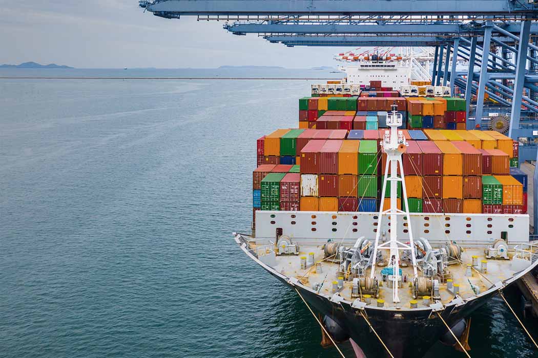 Container ship in port depicting global logistics