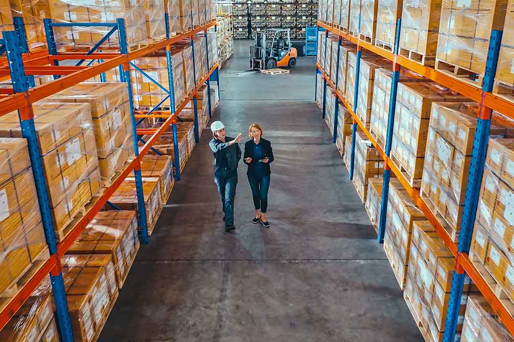 Women in warehouse discussing increased efficiency and cutting costs