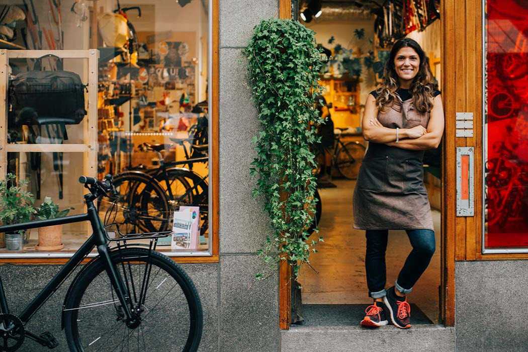 Woman standing in her shop door preparing for Small Business Saturday