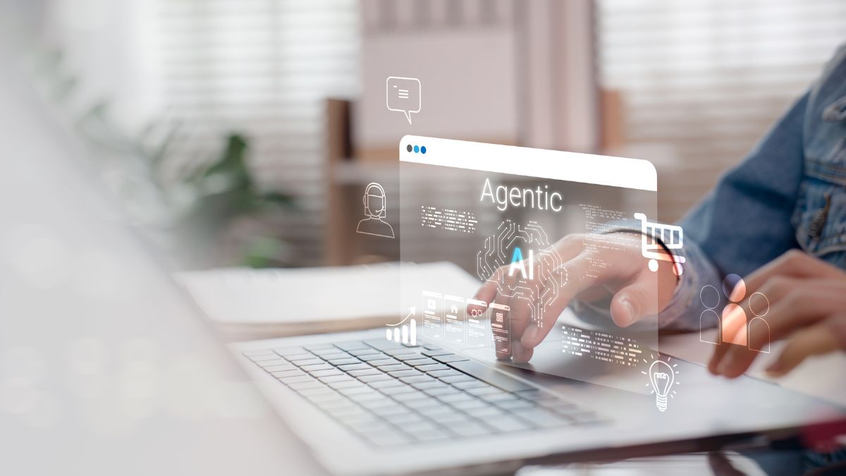Close up of a person typing on a laptop with a digital graphic that says "Agentic AI"