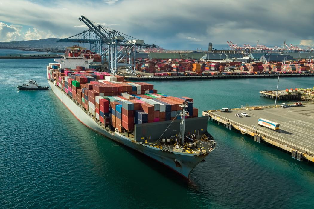 Container ship leaving port depicting key updates from BIS on freight forwarding.