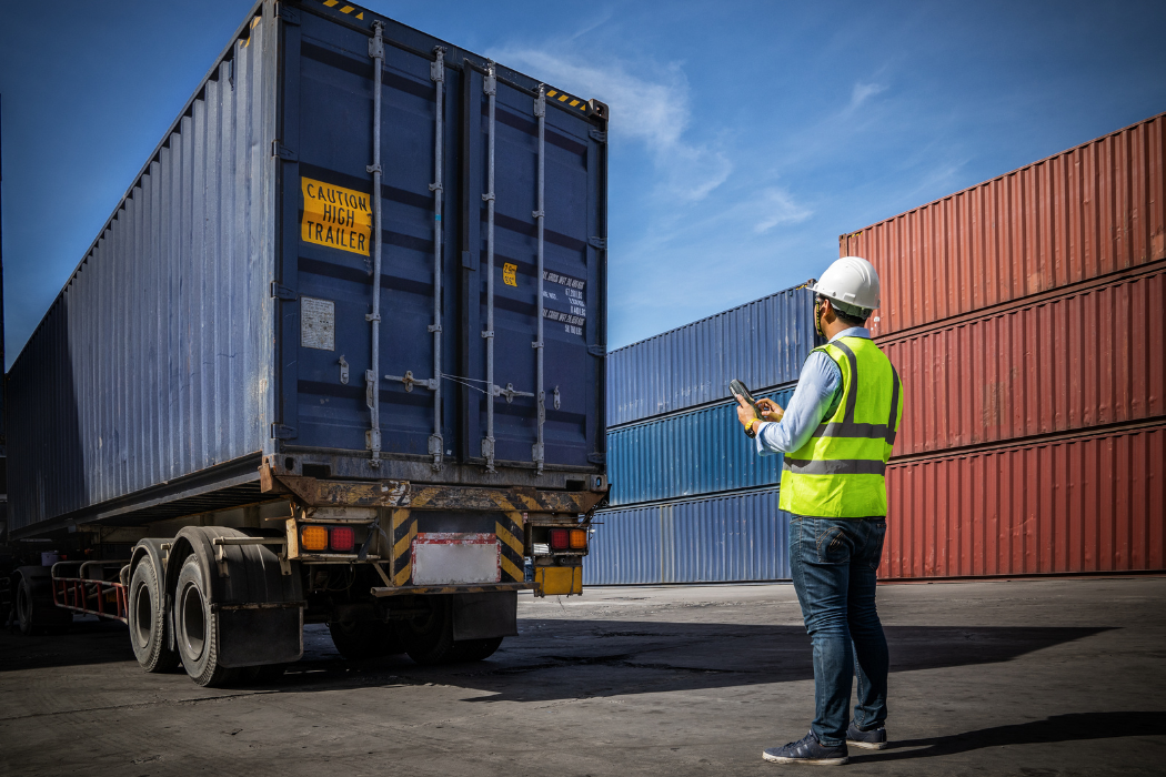 Worker directing a truck as it backs up.